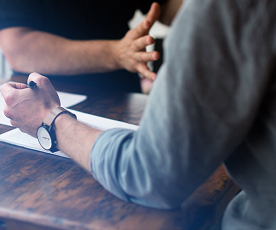 Image of two people filling out forms in an office - representing how Mier Human Capital can help employers